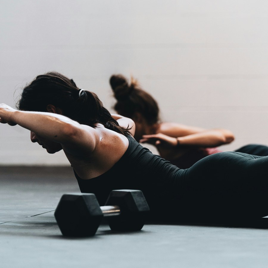Two people doing strength training exercises on the floor